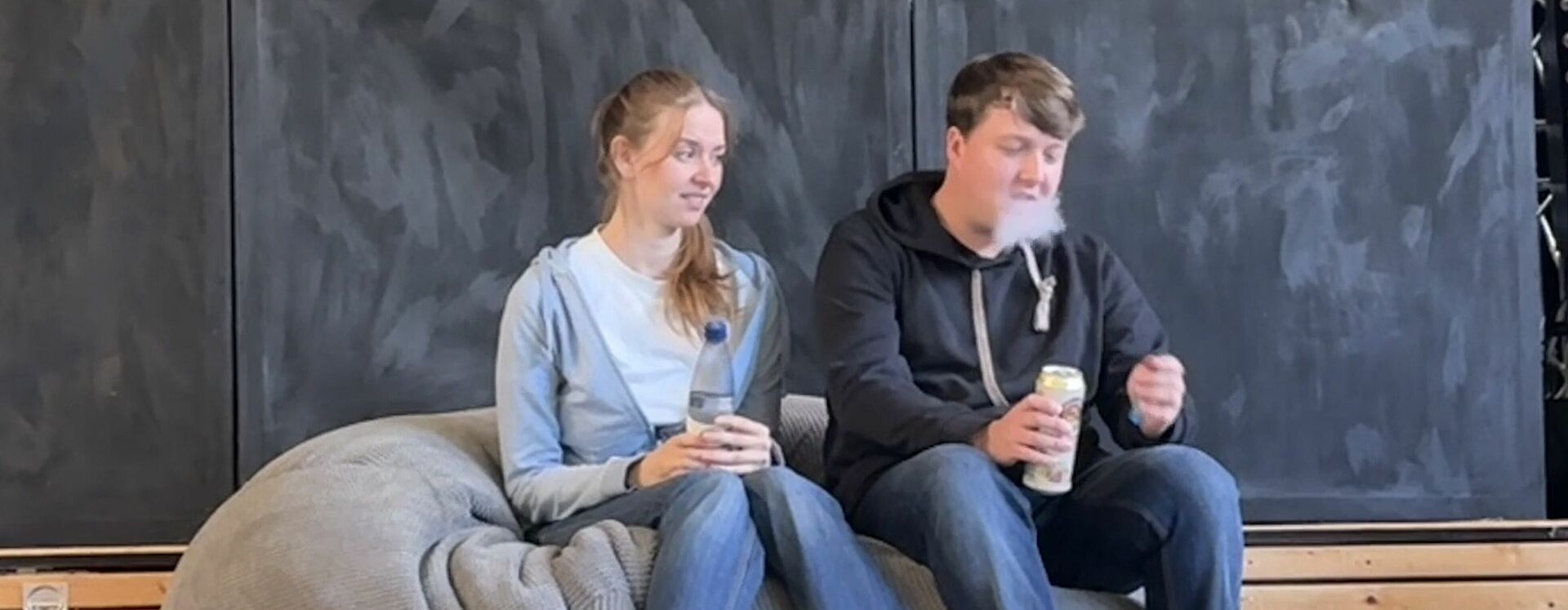 Die Darsteller des 2-Personenstücks sitzen auf der Bühne in einem Sitzsack.